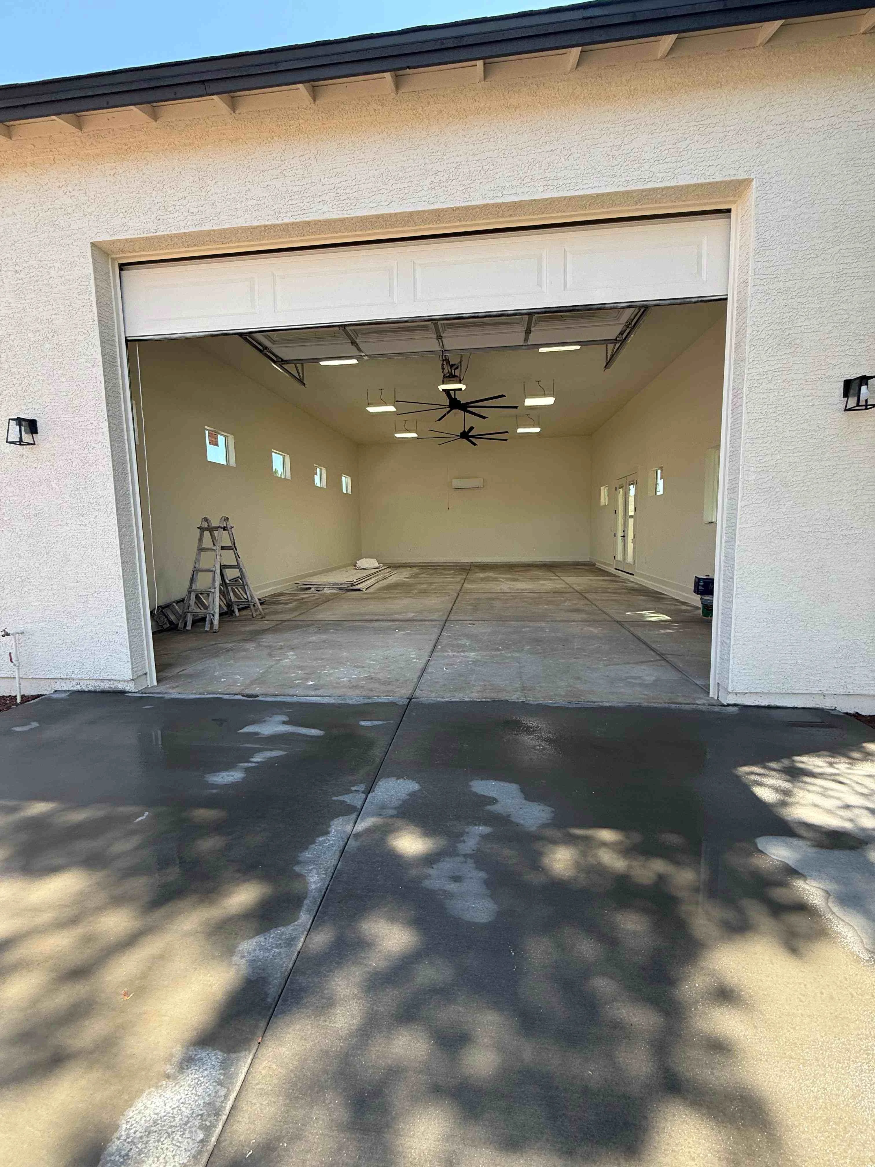 Empty garage interior with drywall, recessed lighting, ceiling fan, and concrete floor