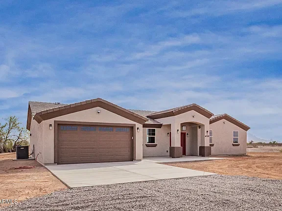 New stucco home with two-car garage, concrete driveway, and gabled roof design