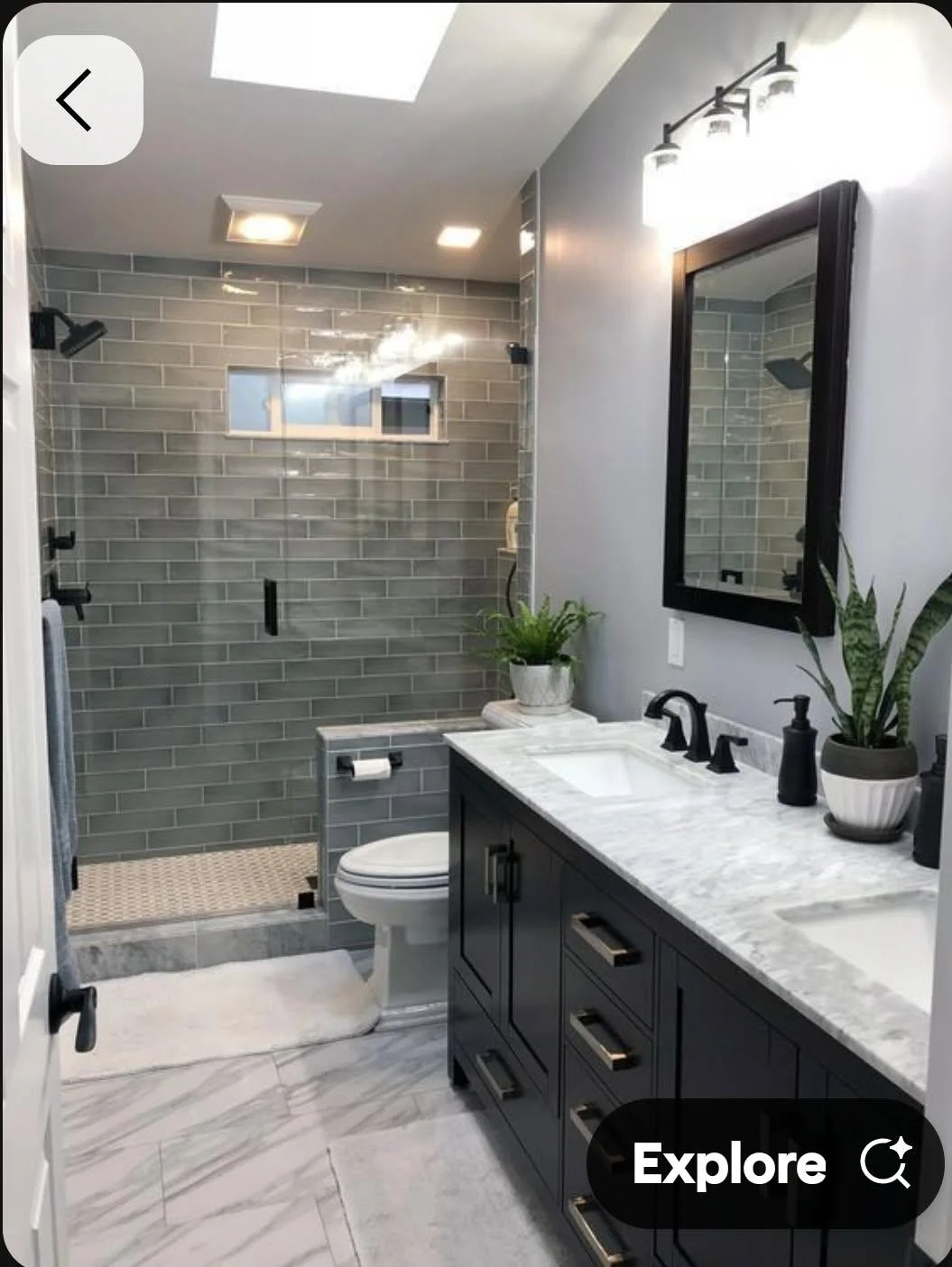 Gray subway tile shower with glass door, marble countertop vanity, dark cabinetry, and recessed lighting